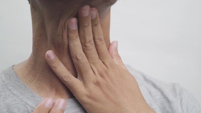 Man touching his throat due to sore throat, pain, or thyroid discomfort.