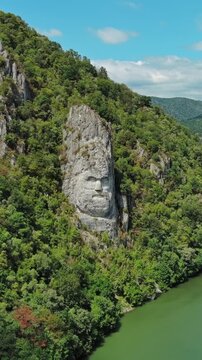 Aerial view of stone carved statue portrait of ancient dacian king Decebal. Sculpture near Danube River, Romania. Vertical video 4k