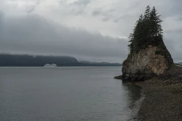 Breathtaking and impressive panoramic scenic view of Icy Strait Point Hoonah, AK coast with lush mountain vegetation and trees during summer Last Frontier cruise with distant mountain range glaciers © Tamme Wichmann