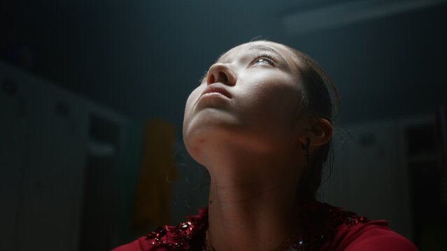 In Moody Locker Room Teen Girl Athlete Experiences Emotional Breakdown Before Major Tournament. Psychological Strain, Pre Performance Anxiety That Generation Z Competitors Face in Elite Youth Sports.