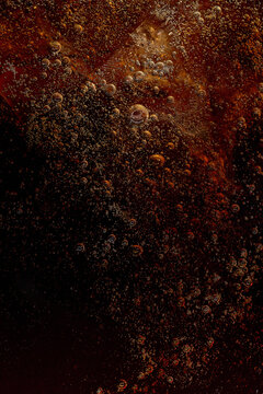 Dark carbonated soft drink with ice cubes and bubbles. Concept of soft drink advertising, beverage packaging, fast food menus, refreshment branding and summer campaigns.