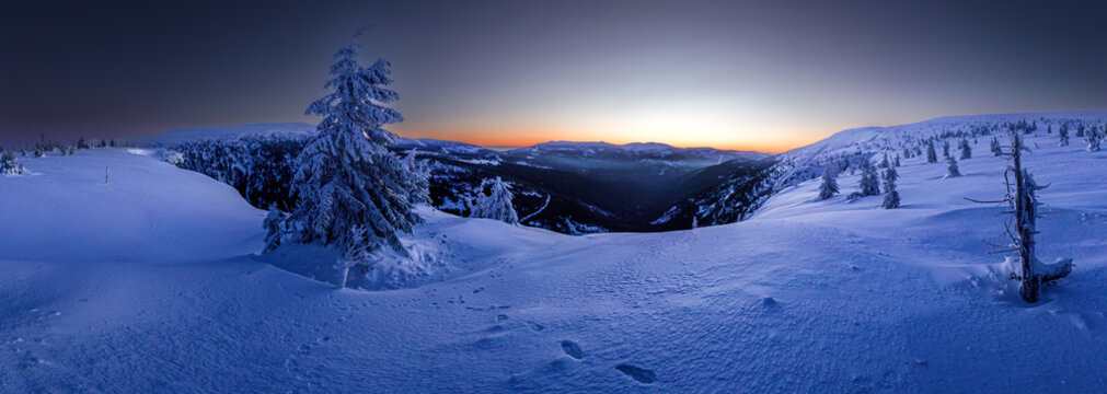 Scenic winter mountain landscape with low sun on the horizon