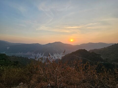 A serene landscape at sunset, showcasing rolling hills and a vibrant sky, creating a tranquil mood perfect for nature lovers and photographers.