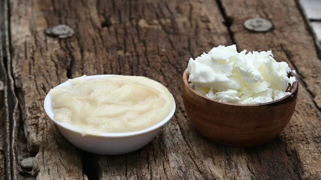Close-up of pure homemade Indian ghee (clarified butter) in a rustic bowl with a wooden spoon on a vintage wooden table. healthy eating, organic dairy, and Ayurvedic wellness.