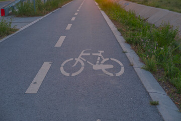 Obraz premium Bike lane marking on asphalt road with bicycle symbol and white lane lines for cycling infrastructure design