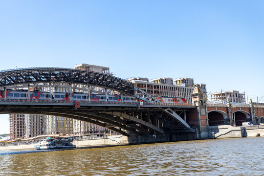 Russia. Moscow. June 06, 2026. Russian railways RZD Lastochka commuter train crossing Luzhnetsky bridge over the city river