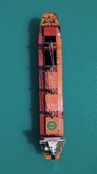 Top Down Aerial View of Cargo Ship in Turquoise Sea