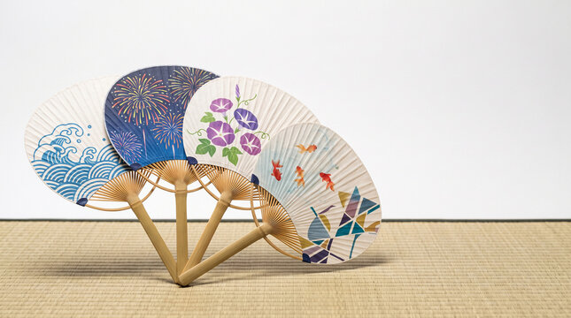 Minimalist composition of traditional Japanese uchiwa paper fans on white tatami mat background