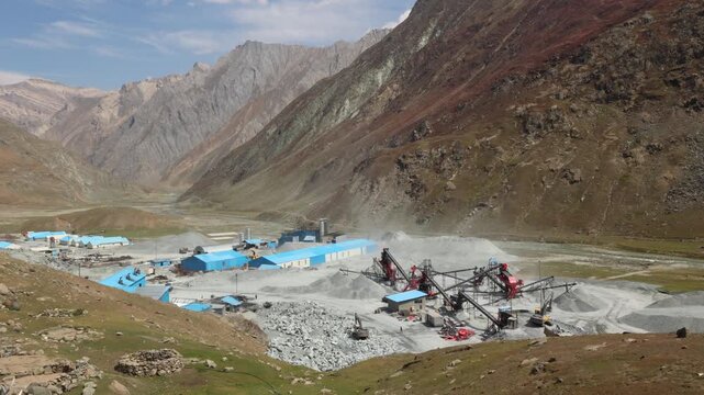 Leh Ladakh India Himalayan Stone crushing machine at open pit mining and processing plant for crushed stone. Piles of gravel stone and conveyor belts. Mining site with excavators destroying mountains