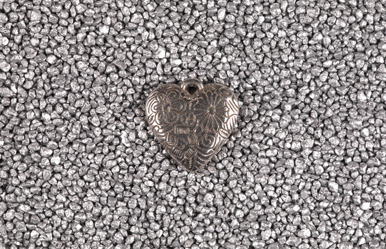 Silver heart pendant isolated on silver sand