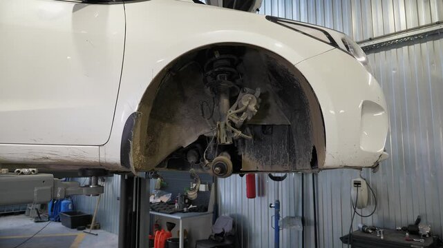 A detailed view of a portion of the vehicle, featuring a wheel that has been completely dismantled, with the brake pad and shock absorbers removed for maintenance. The image is clear and steady.