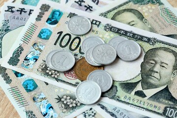 Japanese yen money bills and coins on table. Japan cash of JPY currency close up © Larysa