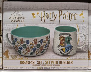 Fototapeta premium Set de tazas de desayuno de Harry Potter, con taza y cuenco decorados con los escudos de las cuatro casas de Hogwarts, en estante de juguetería Toy Planet en Madrid, España, 13 de mayo de 2026