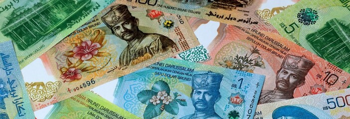 Brunei dollar money banknotes bunch on table. Brunei bills of BND currency close up © Larysa