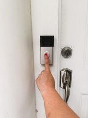 Naklejka premium Home Security Technology with Person Pressing Video Doorbell Button