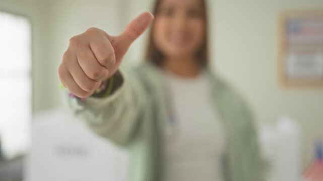 Woman latino shows thumb down hand toward camera at polling booth building with blurred ballot box and usa flag visible; dissent decision.