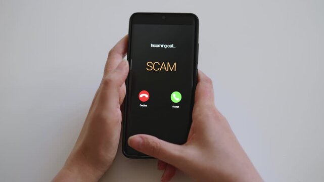 Woman holding smartphone with incoming scam call on screen.