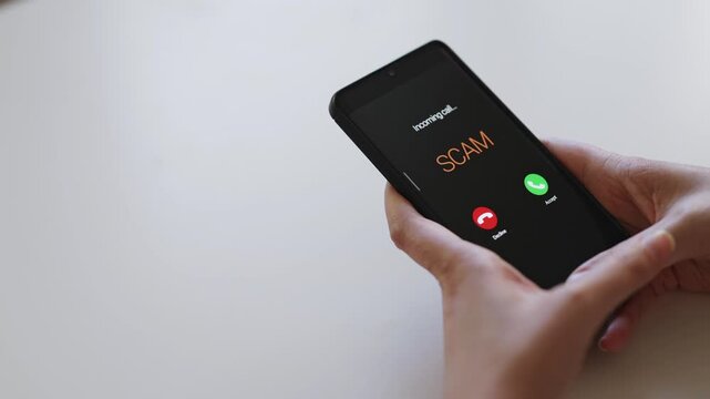 Woman holding smartphone with incoming scam call on screen.