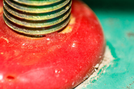 Macro Photography of a Threaded Metal Part on a Vivid Red Textured Surface