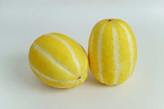 Two Fresh and Ripe Yellow Korean Oriental Melons on a Clean White Background
