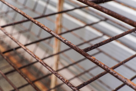 Close up of Old Rusted Metal Grid or Grate with Blurred Corrugated Background