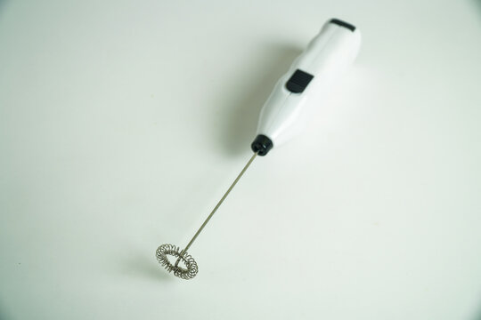 White Handheld Electric Milk Frother on a Clean Light Background