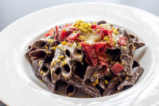 Pennone al grano saraceno con fonduta di fontina, bresaola e pistacchi