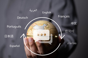 Hand holding a globe with multilingual communication, representing global communication, language translation, international business, cultural diversity, worldwide connection, localization. © Bordinthorn
