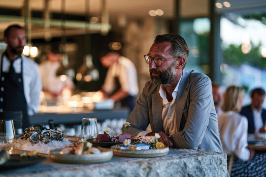 A contemplative man enjoys the plethora of seafood options laid out in an upscale restaurant, embodying relaxation and sophistication amidst the dining experience.