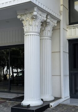 Ornate Corinthian style columns with decorative capitals on neoclassical building facade. Close-up of ornate Corinthian style columns with decorative capitals on a neoclassical building facade.