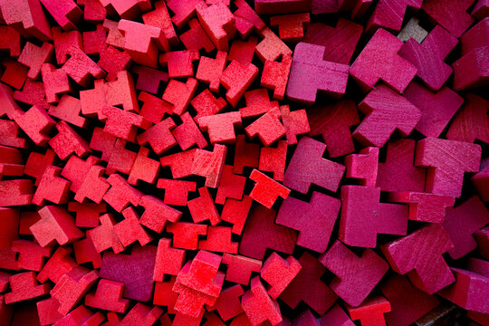Abstract Background of Stacked Red T-Shaped Wooden Blocks in a Dense Pattern