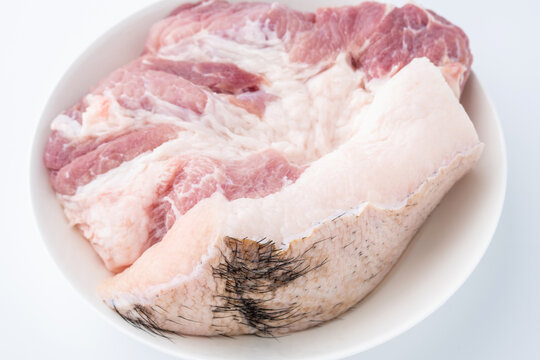 A piece of fresh black-haired pork on a white plate