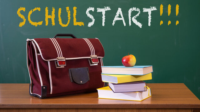 Schulstart, Schulbeginn, Einschulung Gru&szlig;karte, Karte mit deutschem Text - Schulranzen und B&uuml;cher auf Lehrerpult mit Schultafel im Hintergrund