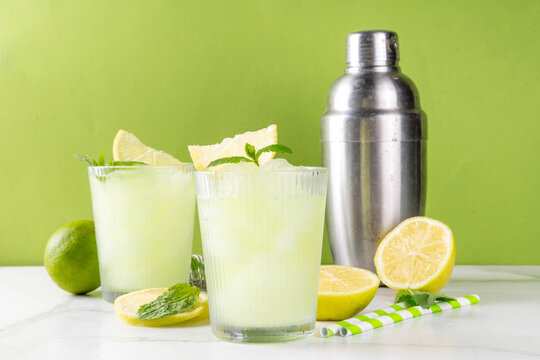 Summer iced slushie lemonade or mojito drink. Tasty low calorie skinny slush cocktail made with crushed lemon, lime juice, with mint. Summer vegan vegetarian non-alcohol cocktail recipe idea