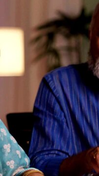 Asian Indian retired couple discussing and planning their investment strategy with a broker , carefully reviewing financial options for their future during retirement