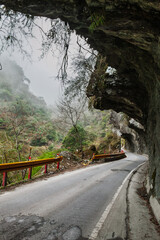 Naklejka premium Mountain road under rock tunnel in Taiwan