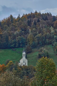Exaltation of the Holy Cross Baroque Church on a grassy hillside among mixed forests, in Pustal village across the river. Skofja Loka-Slovenia-140
