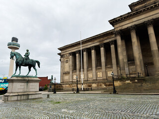 Obraz premium Neoclassical St George's Hall with equestrian statue on empty cobbled plaza under overcast sky in Liverpool, UK
