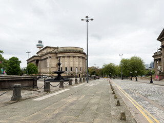 Obraz premium Historic neoclassical St Georges Hall with fountain and empty plaza in Liverpool, UK under overcast sky