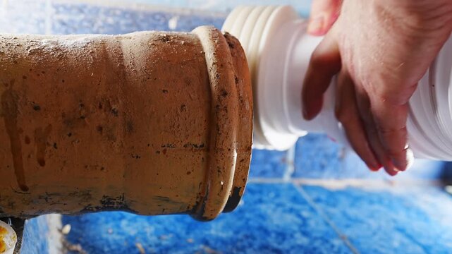 Plumber connects sewage drain pipe in residential bathroom