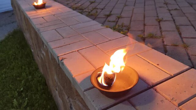 Fire flashes in bowl on a parapet outside