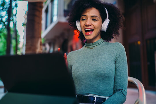 young Hispanic woman reading instant chat notifications on electronic tablet screen inside cozy city cafe lounge, thoughtful Gen Z student waiting for online message feedback near desk