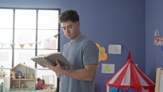 Man holding book open and reading pages in a classroom building, focused on the text and pointing to a line; calm learning.