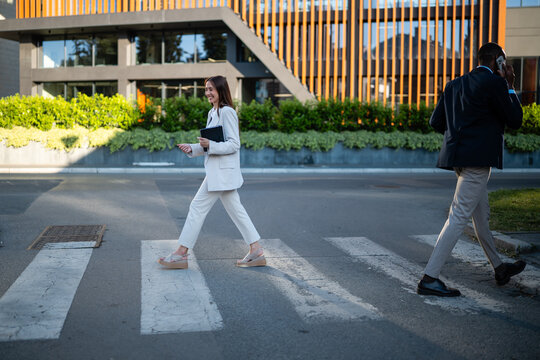 Business professionals walking across street in city