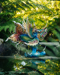 Obraz premium Colorful Dragon Statue Reflecting in Pond