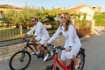 Obraz premium Couple Cycling Through Mediterranean Neighborhood On Relaxed Summer Vacation Morning