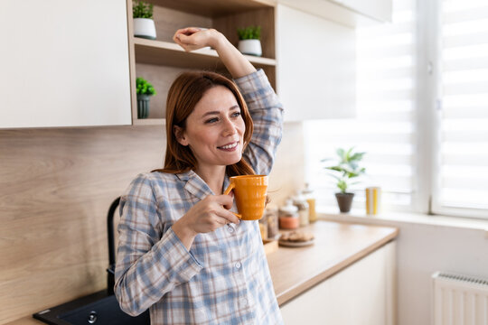 Woman enjoys coffee in modern kitchen at home