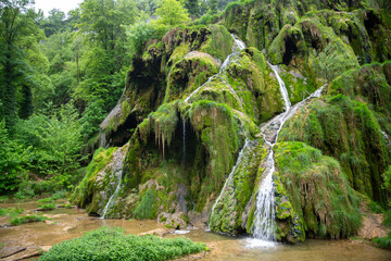 Moss-Covered Waterfall Cascades Through Lush Green Forest With Rocky Terraces And Tranquil Pool © Chris Willemsen
