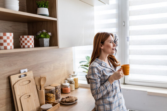 Woman enjoys coffee in modern kitchen at home