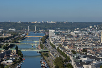 Obraz premium High angle panoramic view of Rouen cityscape, the Seine river, and its historic bridges under a clear sky in France. Beautiful urban landscape.